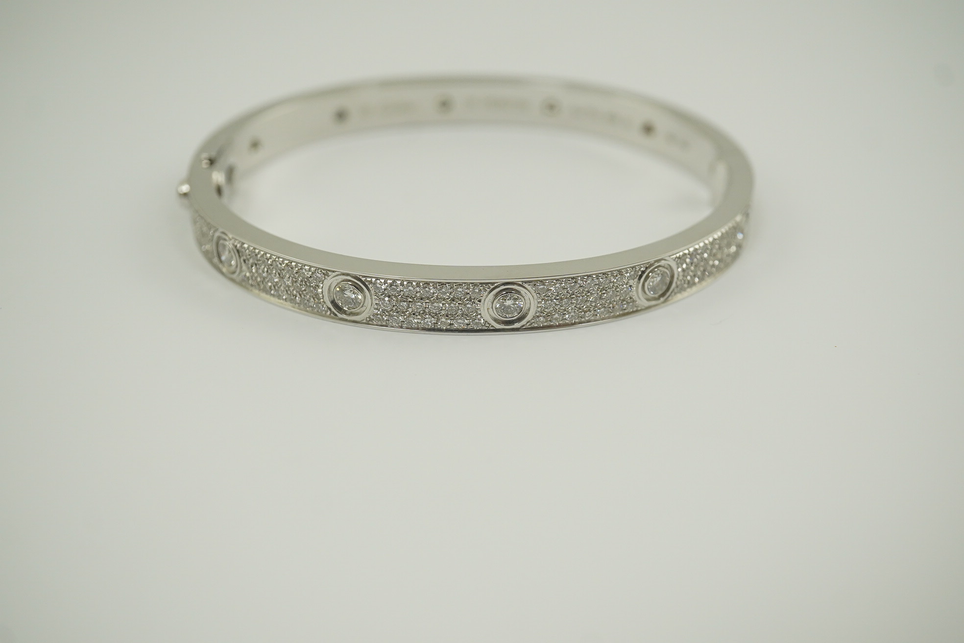 A modern Cartier 18k white gold and diamond cluster set hinged 'Love' bangle